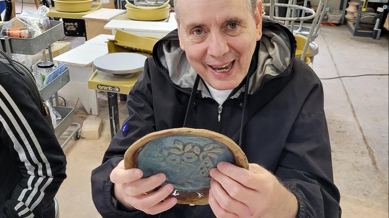 Adult holding pottery