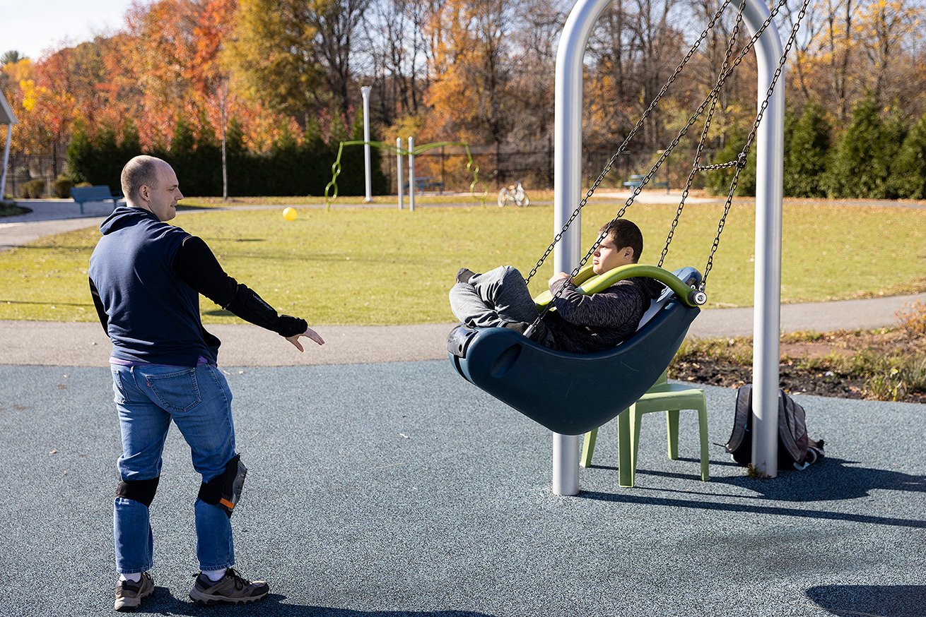 Adult pushing child on a swing