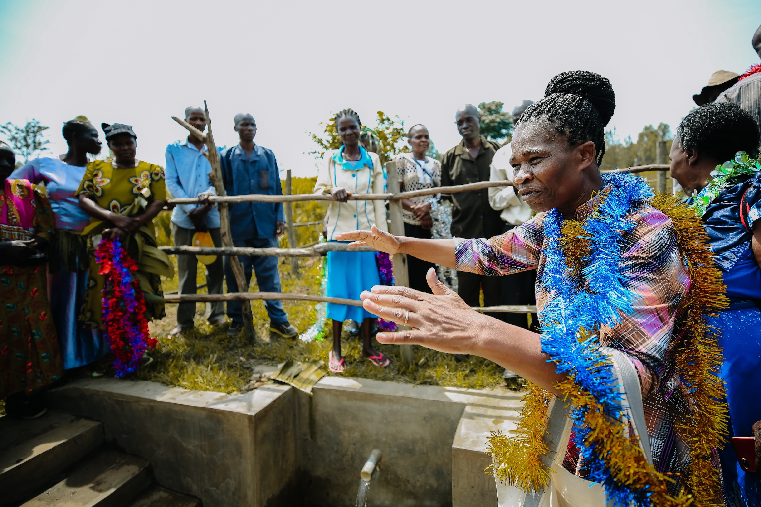 Community leader speaking to villagers gathered at site of new water point