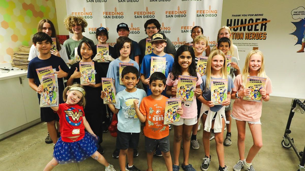 Group of kids holding Hunger Action Heroes Unite! Comic Book