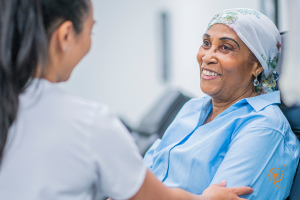 a massage therapist talking to a woman receiving an infusion