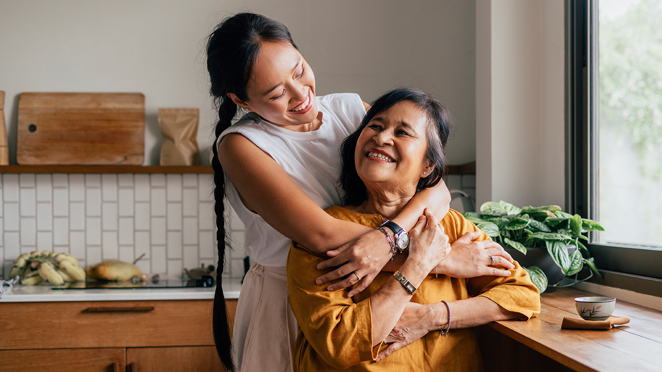 A young woman with her arms around an older woman