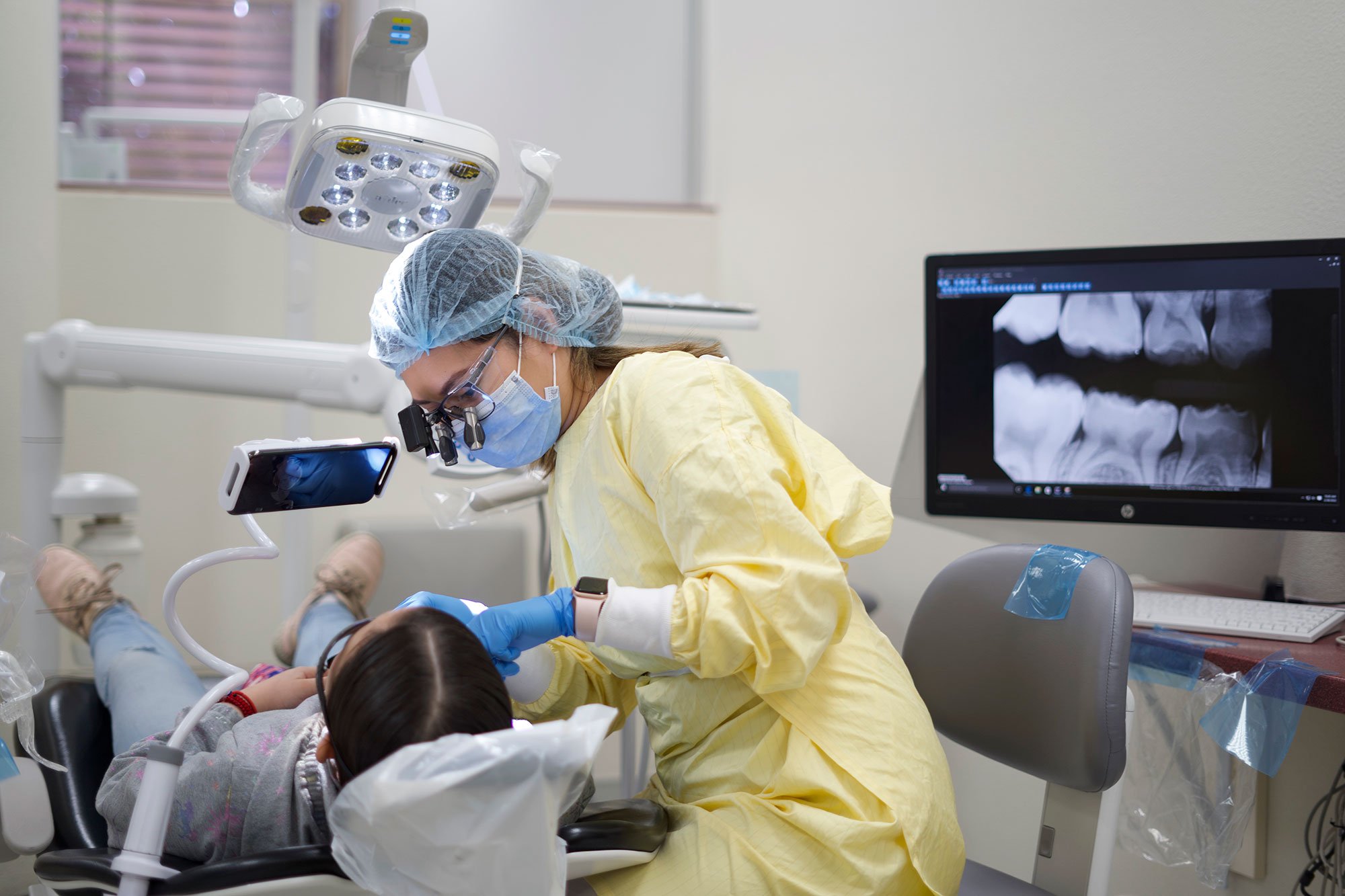 A dental student performing a procedure on a patient