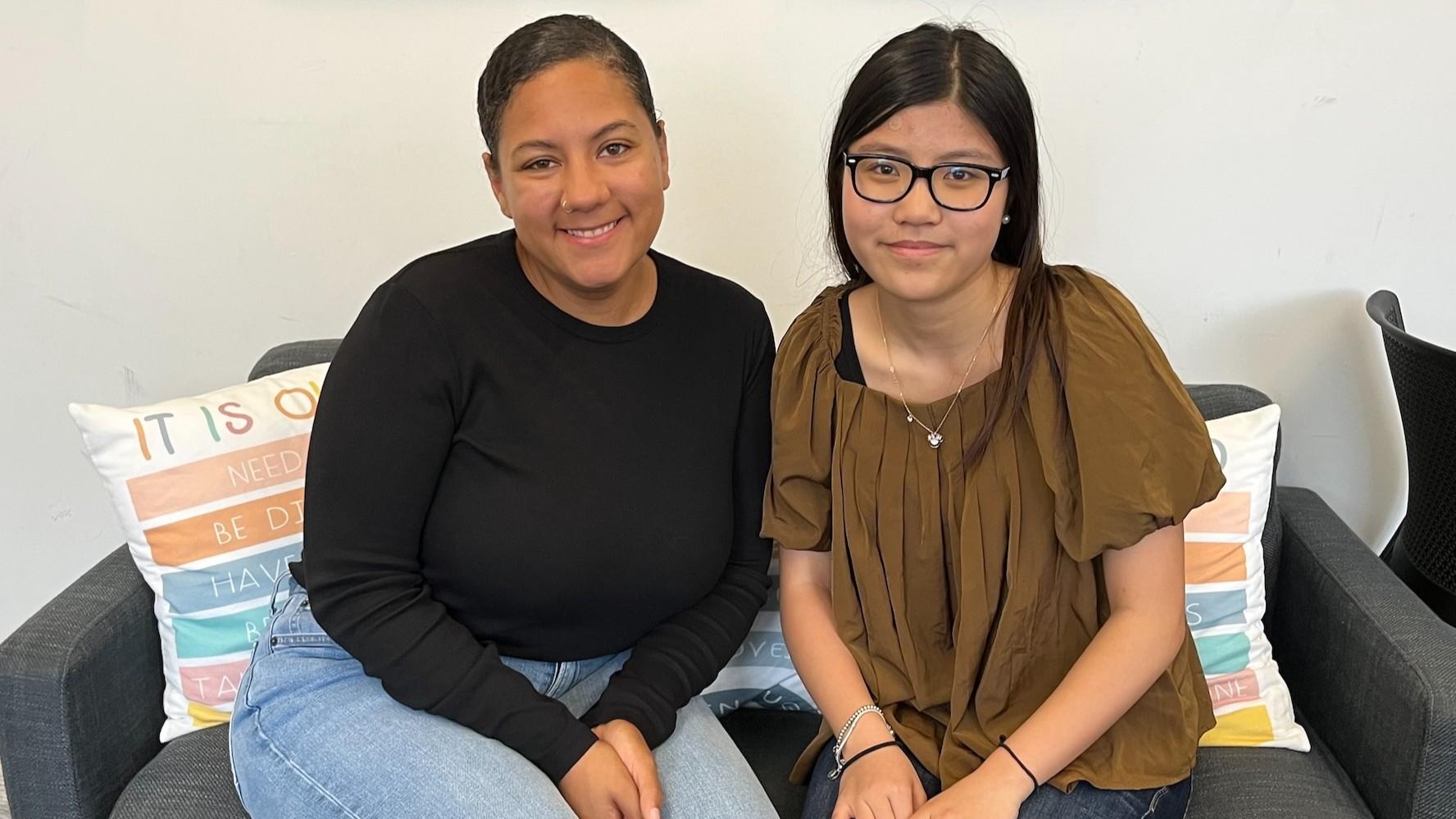 A counselor talks with a high school student on a comfy couch.