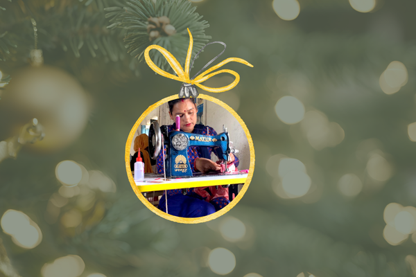An image of a Christmas ornament featuring a Nepali seamstress. 