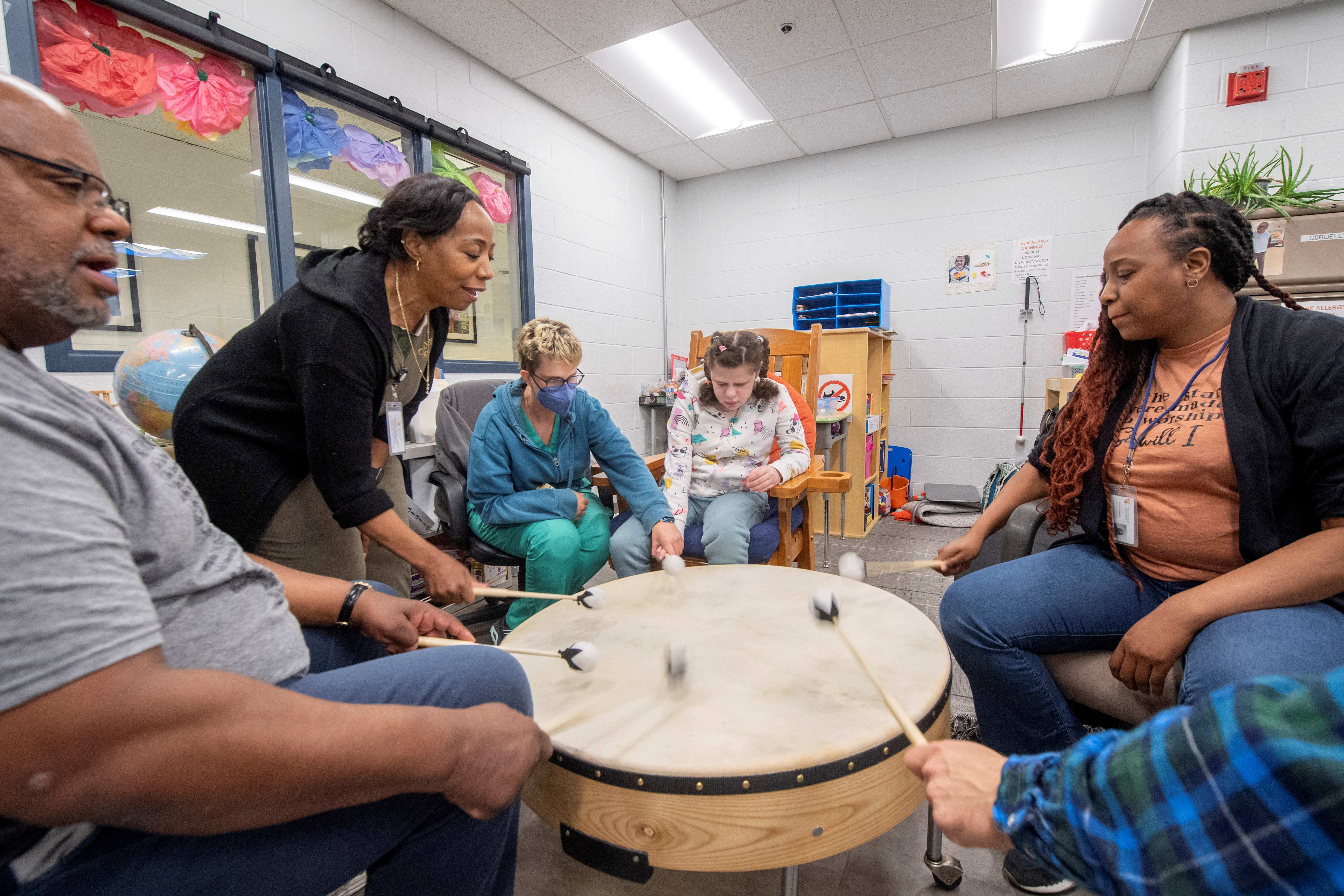 A group of students, teachers and paraprofessionals in our Children's Development Center feel the rhythm as they participate in a music session.