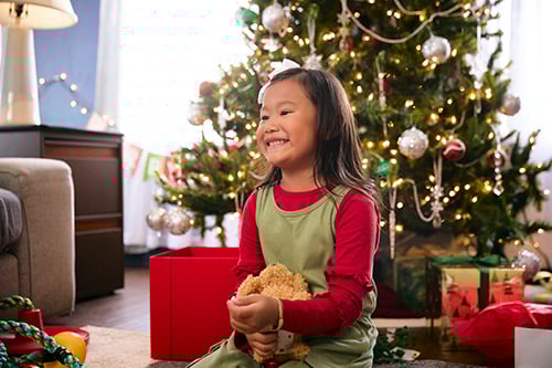 A young child donating to a Salvation Army kettle.