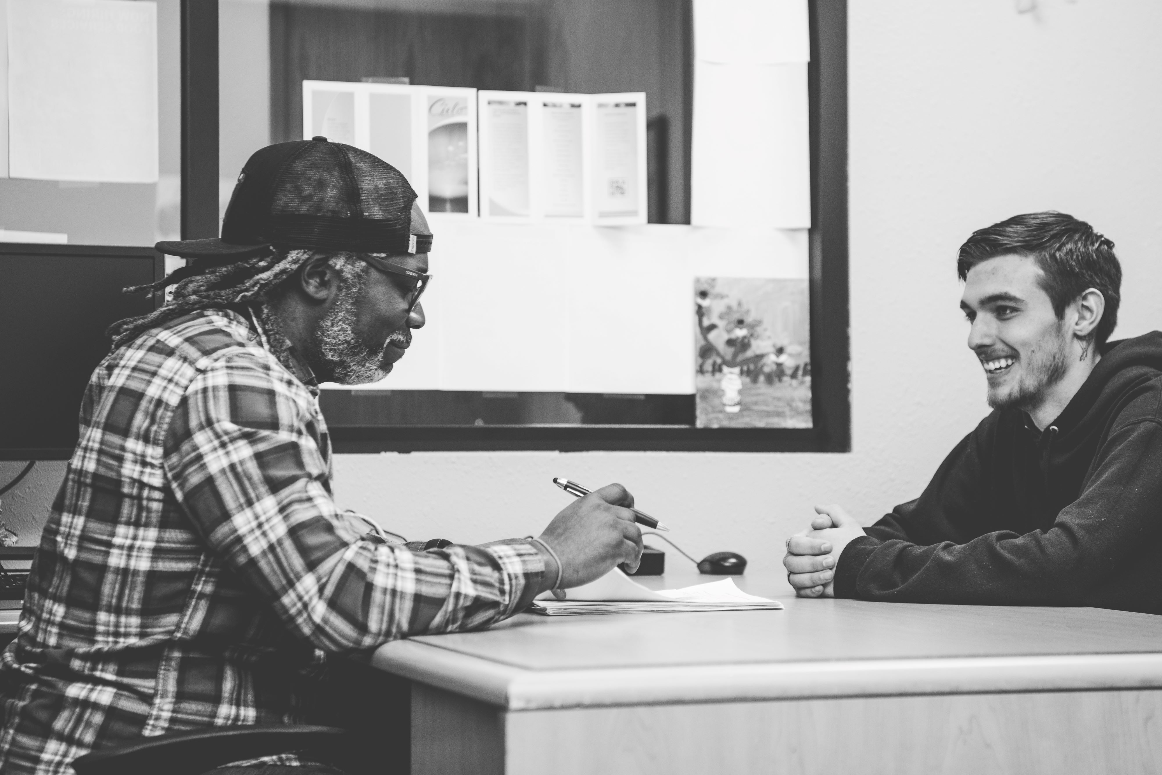 A case worker smiles as he assesses the needs of a potential new program trainee.