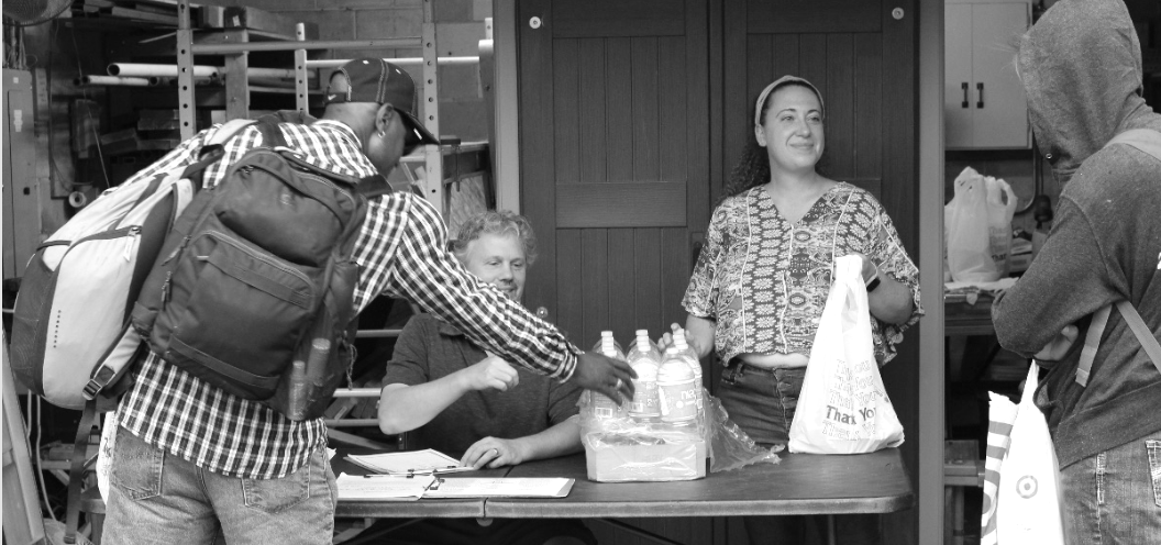 Image of Bridge House providing meals for individuals who are facing food-insecurity. They are all smiling.