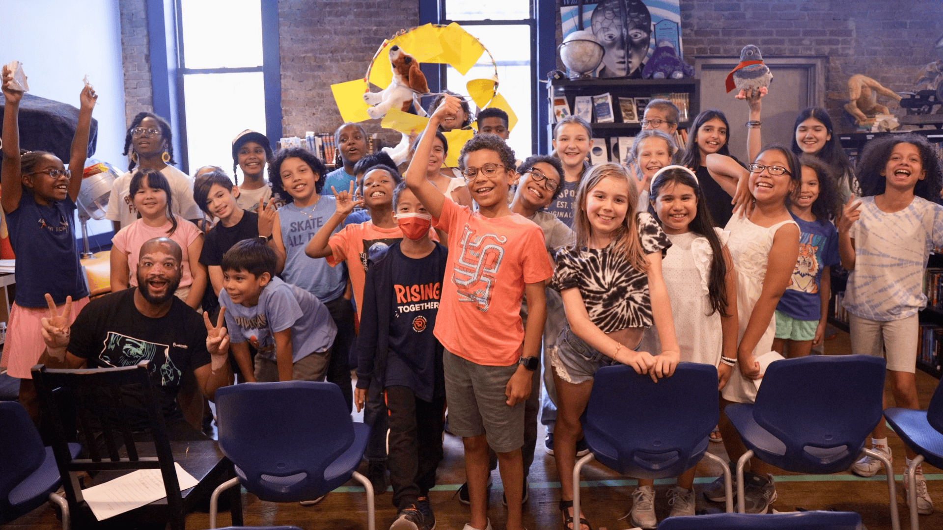 A group of 826NYC students stands together smiling, facing the camera.