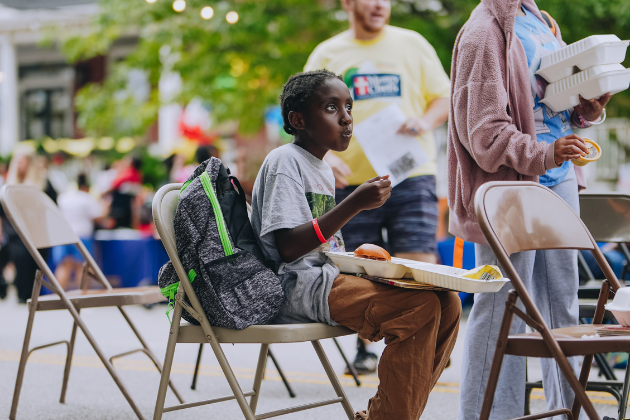 A young boy receives a Mercy Chefs backpack and meal in Virginia.