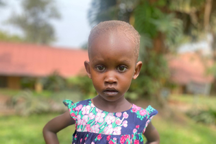 A young Ugandan girl in LWB's cardiac program wears a beautiful floral dress.