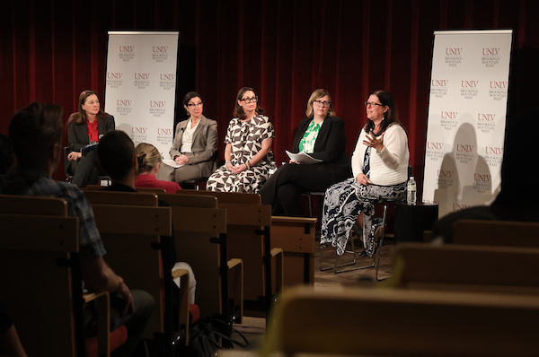 Panel of scholars on stage.