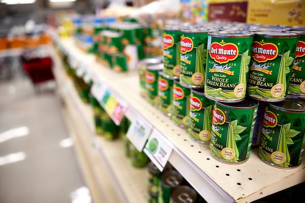 A close-up of canned food on the food pantry shelf.